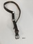 A leather horse harness strap comprising of three segments, two metal rings and a buckle at one end.