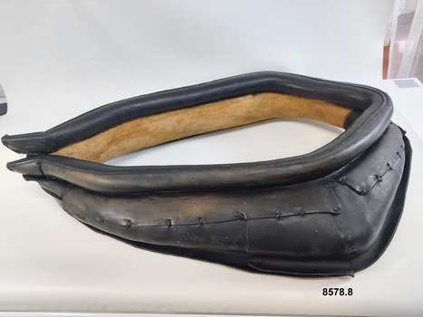 Leather horse collar showing stitched leather segments on top half and untreated leather on the underneath