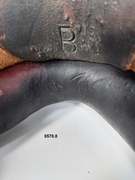Close up view of the letter B stamped onto the collar near the bottom curve