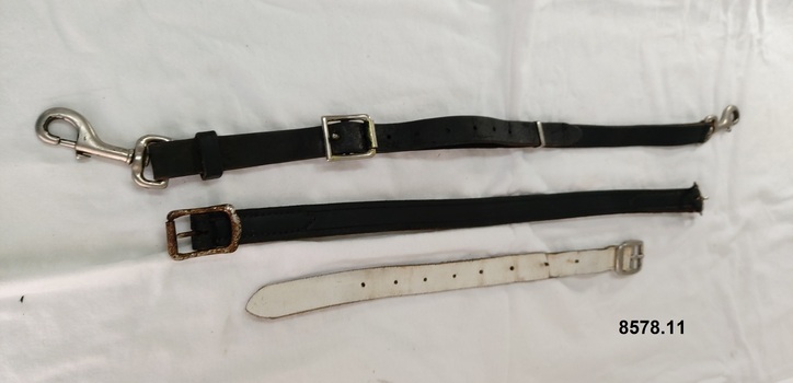 Three assorted short leather straps belonging to a horse harness