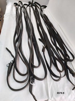 Two pairs of long leather straps - each with a buckle and notched section at one end