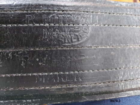 Close up view of maker's stamp on leather strap which reads "R. Mitchell Maker"