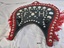 Front of a red and black vinyl covered Housen showing the decorative red fringe and silver stud design and the two leather loops that attach to the hames