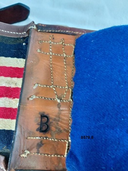 A stamped letter B on a leather section on the underneath of the harness backband