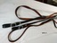 A pair of leather traces each featuring a buckle and notched end and silver diamond shaped ornamentation