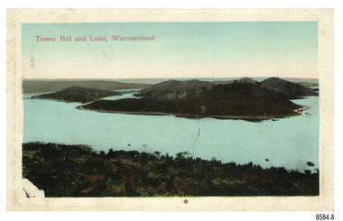 Rectangular landscape postcard showing islands in a lake with hills in the background
