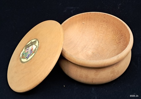 A round wooden box with lid, originally containing powder made by Fauldings.