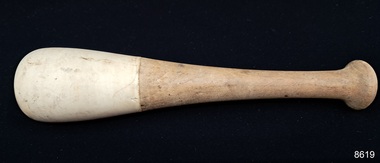 Wooden handle with a knob on top, flaring out to a white ceramic end with a rounded base