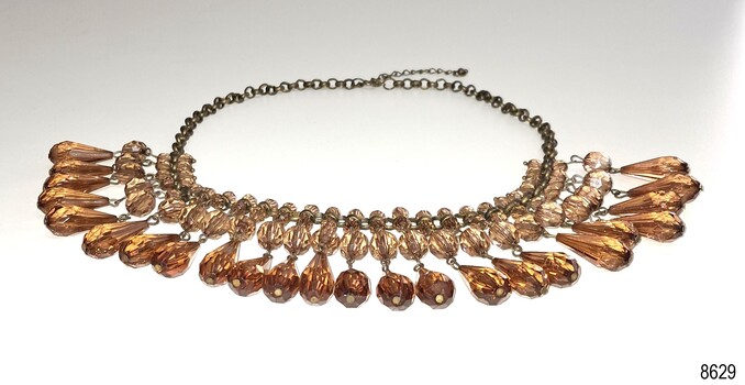 Teardrop shaped amber beads with prism sides, joined to round beads, assembled on a chain