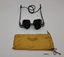 Orange fabric pouch to hold black optician's spectacles that have a cord for hanging around the neck.
