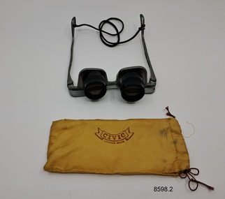 Orange fabric pouch to hold black optician's spectacles that have a cord for hanging around the neck.