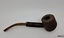 A collection of six pipes. Two of the pipes are resting in their protective cases. One of the pipes is the old fashioned clay type.