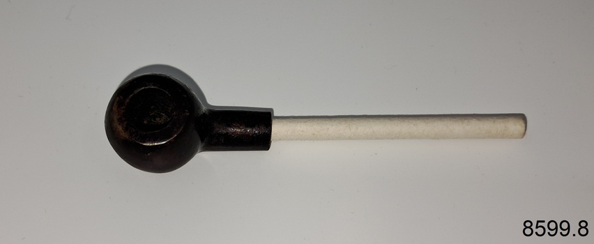A collection of six pipes. Two of the pipes are resting in their protective cases. One of the pipes is the old fashioned clay type.