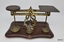 Set of metal scales on wooden base together with four different weights.