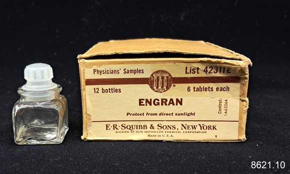 Glass bottle on bench beside a cardboard box