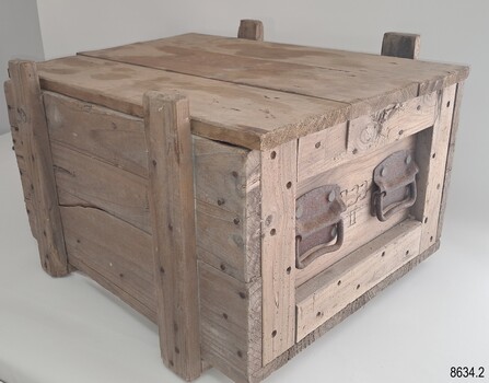 Wooden crate with metal handles at each end and a removable wooden lid