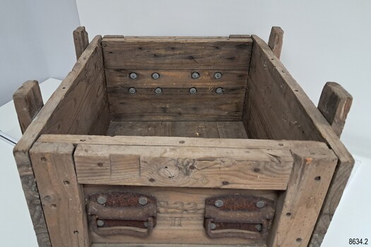 Wooden crate's pairs of handles at each short side are fixed to wood with strong metal bolts