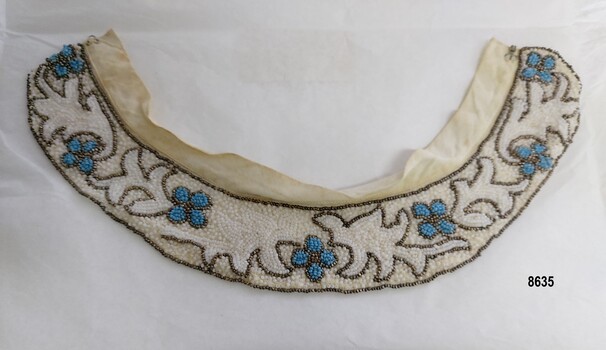 Lady's beaded collar with design of leaves and blue flowers