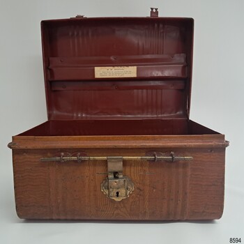 Tin trunk is painted dark red inside and has reinforcing in the top handle section