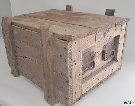 Strong unpainted wooden crate with metal handles and a lose lid