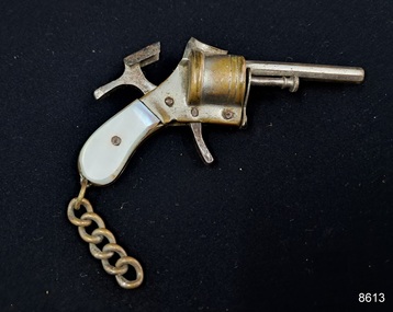 A cigarette lighter is shaped like a small pistol with a plastic handle and a short chain attached.