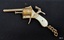 A cigarette lighter is shaped like a small pistol with a plastic handle and a short chain attached.