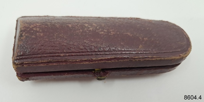 Closed brown case has a textured surface, with some wear
