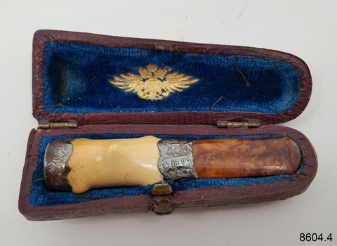 Open case shows blue lining. It has an inscription. The two-tone mouthpiece has a silver fitting