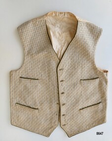 Front view of vest showing patterned fabric, four pockets and buttonholes.