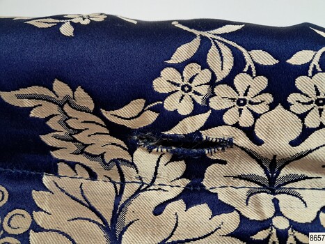 The reverse top hem, centre, has a button hole worked into it