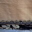 Reverse side, showing woven cream lining, and braid across the hem