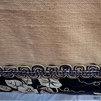 Reverse side, showing woven cream lining, and braid across the hem