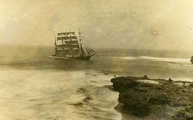 Postcard with a sepia photo of a sailing ship near a cliff