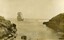 Postcard with sepia photo of a sailing ship approaching two rocky headlands