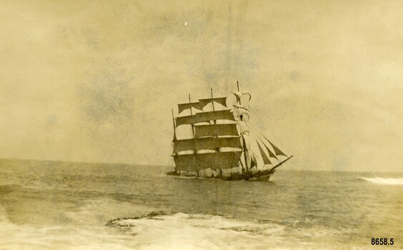 Postcard with sepia photo of a sailing ship near a shallow rocky reef