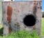 Square sheet of metal with rivets across the top and circular hole towards the right