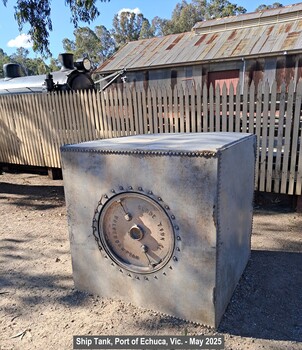 Ship tank outside a picket fence and steam train locomotive
