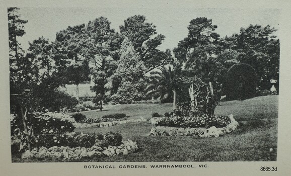Trees and garden beds on a sloping neat lawn