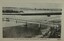 Footbridge over a river with a road and bay in the background