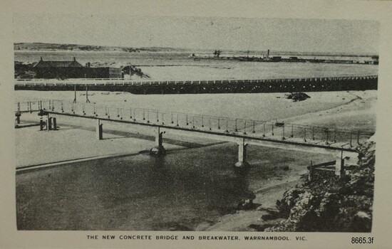 Footbridge over a river with a road and bay in the background