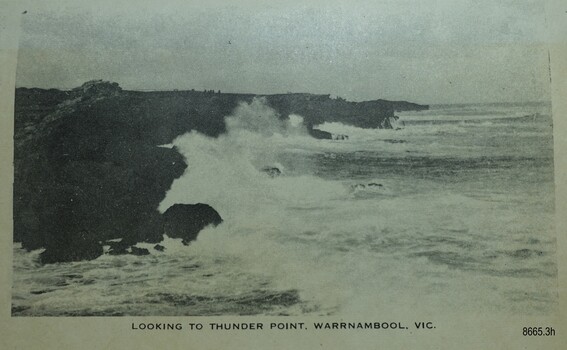 Waves crashing against cliffs along a rocky shoreline
