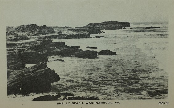 Rock shelf with shallow water beside rocky shoreline 