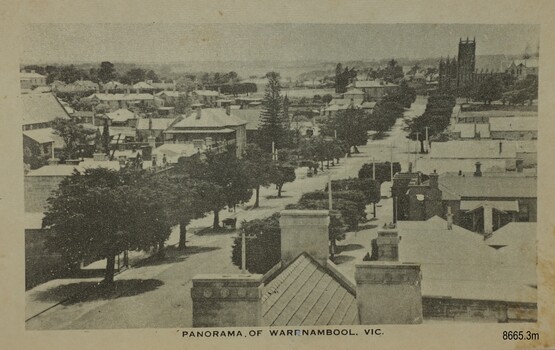 Trees along one side of a street that leads to a Turreted building at the end