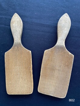 Pair of butter pats showing the side with fine groves.