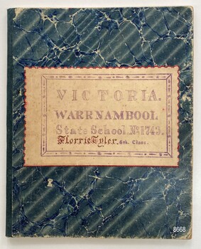 Front cover of school exercise book displaying school details and name of student.