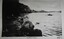 Black and white image showing a figure in a rowboat on a river