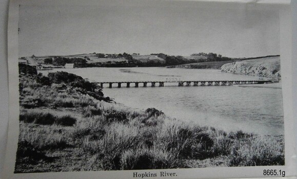 Bridge across a river between land, some cleared, some bushy