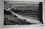 Curved road between land, sloping towards the sea