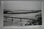 Footbridge over a river, road behind it, Breakwater behind that