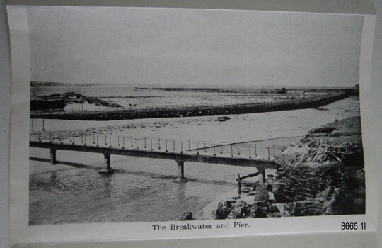 Footbridge over a river, road behind it, Breakwater behind that